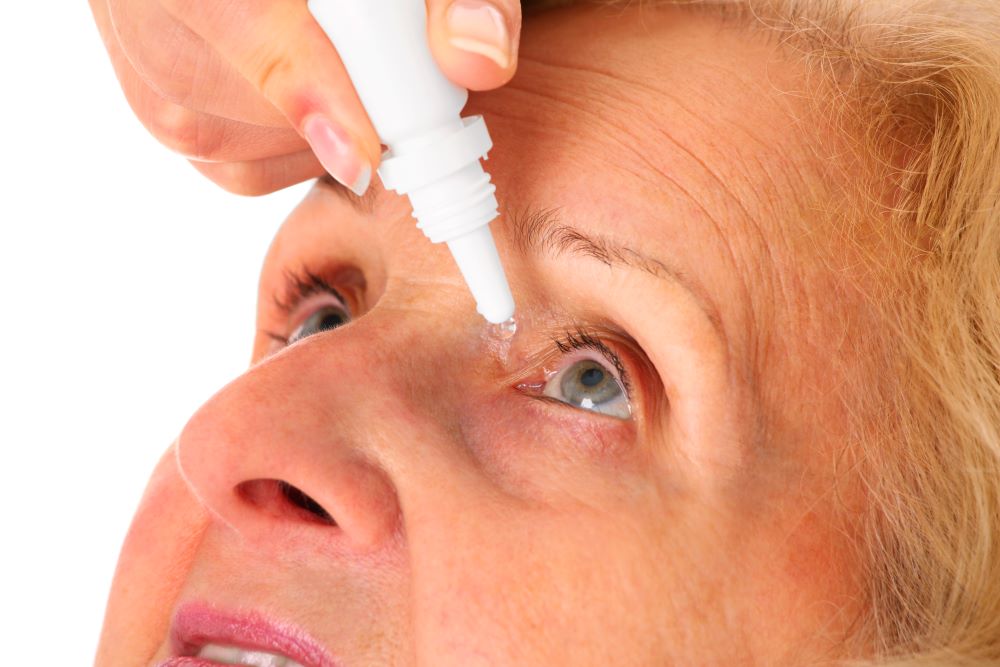 Woman hands putting eyedrops in patient eyes