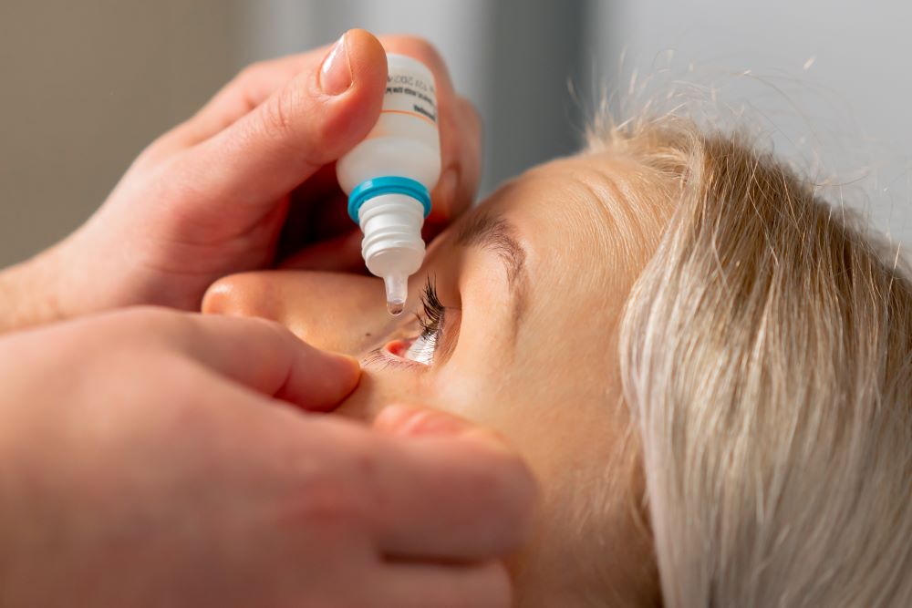 Doctor putting eye drops in senior citizen patient