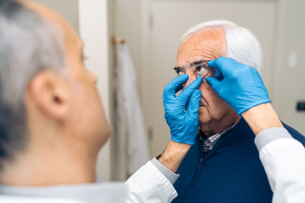 Ophthalmologist analyzing eye of an elderly man in hospital